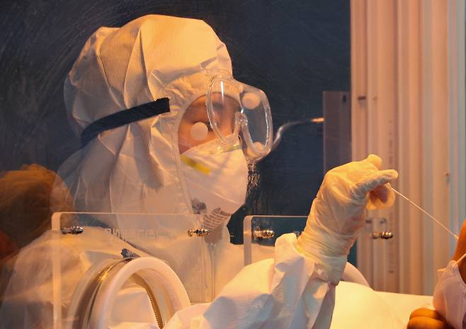 6일 오전 서울역 앞에 마련된 임시선별진료소에서 의료진이 검체채취를 하고 있다. 연합뉴스