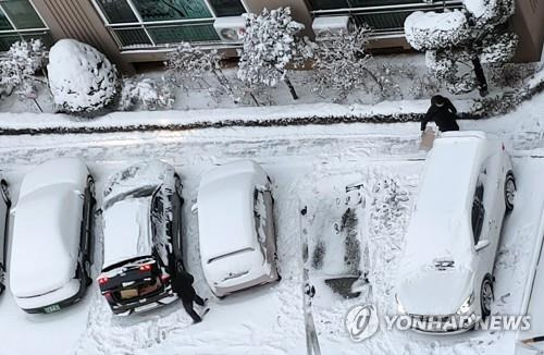 눈이 많이 쌓였네 (전주=연합뉴스) 최영수 기자 = 7일 전북 전주시 서곡의 한 아파트 주민들이 차량에 쌓인 눈을 치우고 있다. 2021.1.7