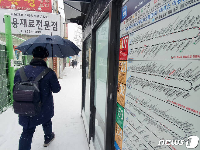 대설 경보가 내린 지난 7일 오전 광주 북구 오치동 한 버스정류장에서 한 시민이 우산을 쓰고 지나가고 있다.2020.1.7 /뉴스1 © News1