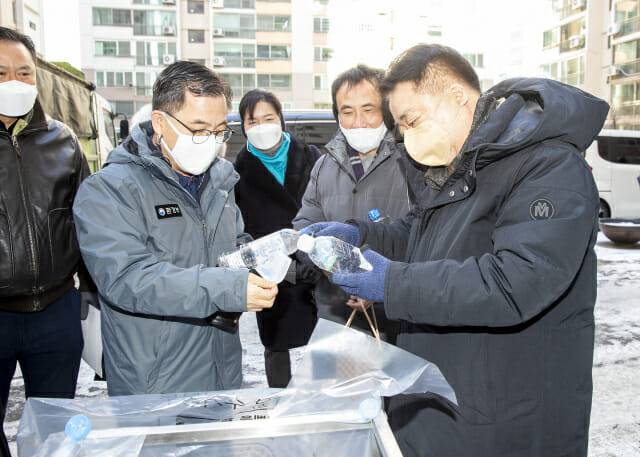 홍정기 차관(왼쪽)이  충북 청주시 소재 아파트에서 투명 페트병 상표띠를 제거하고 있다.