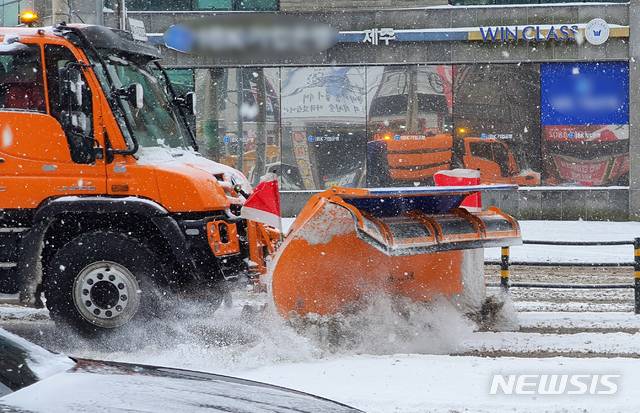 [제주=뉴시스]우장호 기자 = 북극발 한파가 사흘째 기승을 부리고 있는 8일 오전 제주시 이도2동 구세무서 사거리 인근 도로에서 제설차가 부지런히 쌓인 눈을 치우고 있다. 2021.01.08. woo1223@newsis.com
