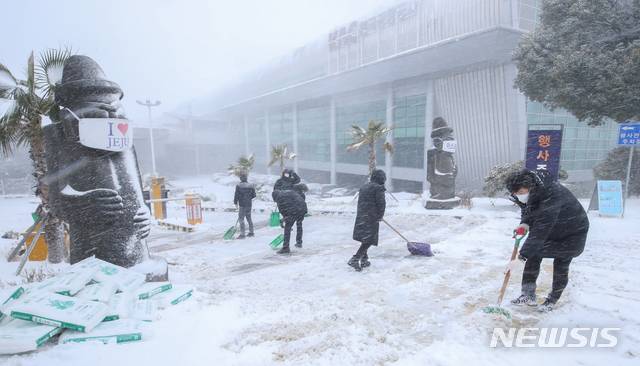 [제주=뉴시스]우장호 기자 = 북극발 한파가 사흘째 기승을 부리고 있는 8일 제주국제공항 주차장 입구에서 직원들이 쌓인 눈을 치우고 있다. 2021.01.08. woo1223@newsis.com
