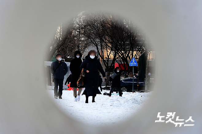 지난 7일 오전 서울 광화문역 인근에서 시민들이 밤사이 내린 눈으로 얼어붙은 길을 따라 출근길을 재촉하고 있다. 황진환 기자