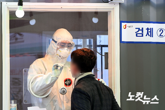 서울역광장에 마련된 임시선별소에서 코로나19 의료진이 검체 채취를 하고 있다.  황진환 기자
