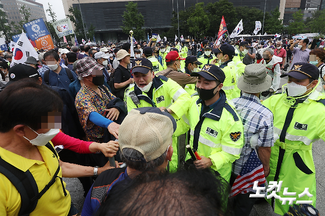 지난해 광복절 보수단체 집회 참가자들이 서울 종로구 광화문광장에서 집회에 참석하기 위해 바리케이드를 밀고 경찰과 대치하고 있다. 이한형 기자