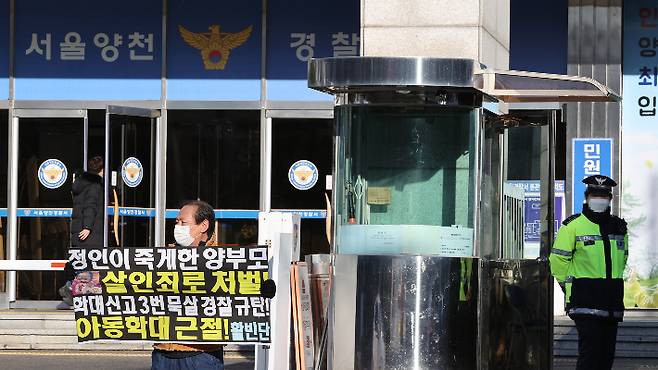 서울 양천구 양천경찰서 앞에서 한 시민이 양부모 학대로 숨진 정인 양 관련 사건 초동 대처 미흡을 규탄하는 손팻말을 들고 있다.  연합뉴스