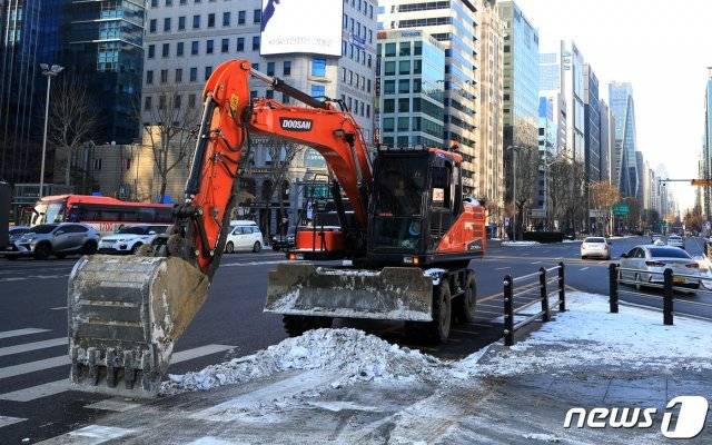 10일 오전 서울 강남구 삼성역네거리에서 굴삭기를 동원한 제설작업이 한창이다.