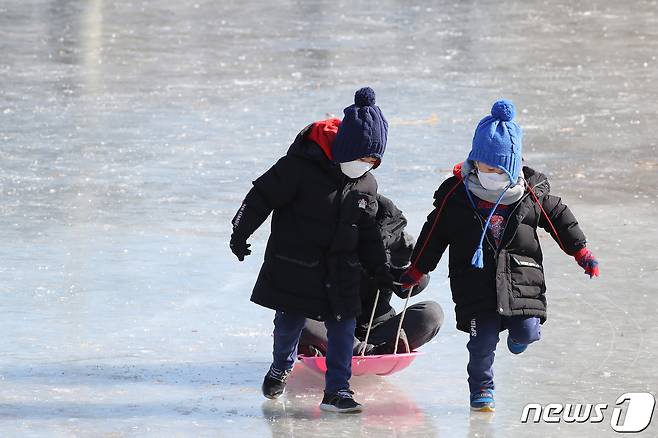 10일 최근 이어진 한파로 경북 경산시 영대교 아래 남천이 꽁꽁 얼자 휴일을 맞아 어린이들이 추위에도 아랑곳하지 않고 얼음을 지치고 있다. 2021.1.10/뉴스1 © News1 공정식 기자