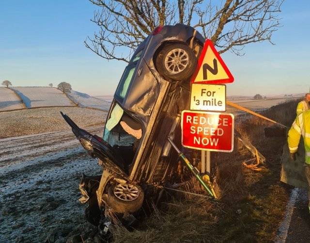 지난 9일(현지시간) 영국 더비셔주의 한 마을에서 도로를 달리던 차량이 빙판에 미끄러져 전복됐다. 차량에 타고 있던 일가족
 3명은 무사히 구조됐다. 해당 자량이 ‘속도를 줄이시오’ 표지판 옆 거꾸로 박혀있는 모습. ‘채플온콜’ 소방서 제공