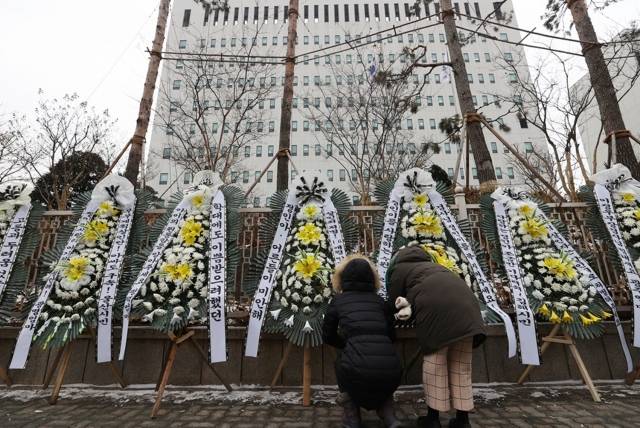 대한아동학대방지협회관계자들이 11일 오전 서울 양천구 남부지방검찰청과 남부지방법원 앞에 정인이 양부모에 대한 엄벌을 촉구하며 근조화환과 바람개비를 설치하고 있다. 연합뉴스