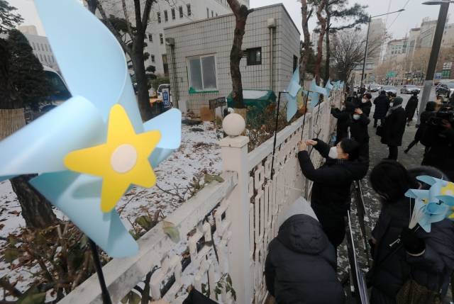 정인이 양부모에 대한 재판을 이틀 앞둔 11일 오전 서울 양천구 서울남부지방검찰청 앞에서 대한아동학대방지협회 회원들이 학대 피해 아동을 추모하는 푸른색 바람개비를 담장에 달고 있다. 뉴시스