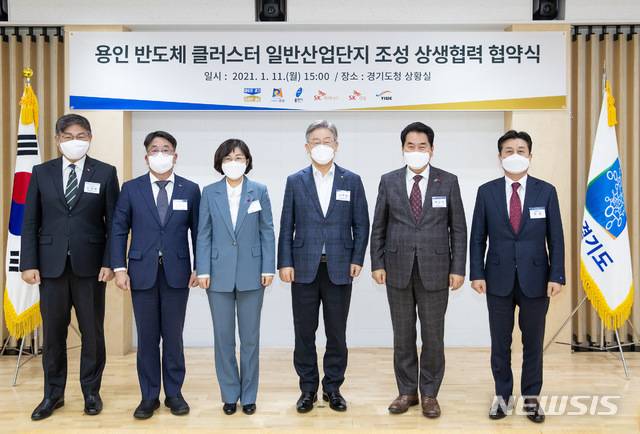 [수원=뉴시스] 11일 오후 경기도청 신관2층 상황실에서 이재명 경기도지사, 김보라 안성시장, 백군기 용인시장, 김동섭 SK하이닉스(주)사장, 안재현 SK건설(주)대표이사, 정철 용인일반 산업단지(주) 대표이사와 관계자들이 참여한 가운데 용인 반도체 클러스터 일반산업단지 조성 상생협력 협약식을 마친 후 기념촬영을 하고 있다. 2021.1.11. (사진=경기도 제공)