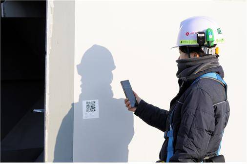 롯데건설 관계자가 ‘엘로세움’ 애플리케이션으로 현장 반입 부재의 QR코드를 스캔하고 있다. 엘로세움은 롯데건설이 자체 개발한 스마트건설 현장관리 플랫폼으로 금강보행교 등 각종 건설현장에 적용되고 있다.