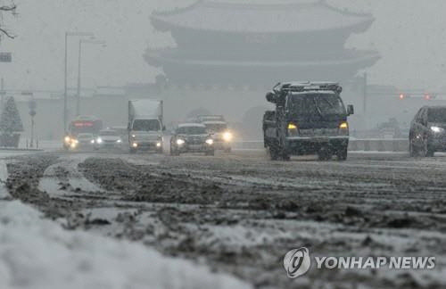 서울 지역에 눈이 내린 12일 오후 서울 종로구 세종대로에서 차들이 눈길을 서행하고 있다.  연합뉴스