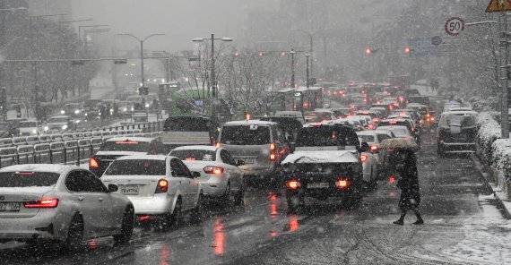 12일 오후 서울 신도림역 주변에 눈이 내리기 시작해 시민들이 눈을 맞으며 횡단보도를 건너고 있다. 기상청에 따르면 서해상의 눈 구름대가 내륙으로 유입되면서 서울과 경기도 등에 눈이 내리기 시작해 저녁때는 눈이 내리는 지역이 점차 확대될 것으로 예상되어 퇴근길 교통 체증이 심하게 빚어질 것으로 예상된다. 사진=박범준 기자