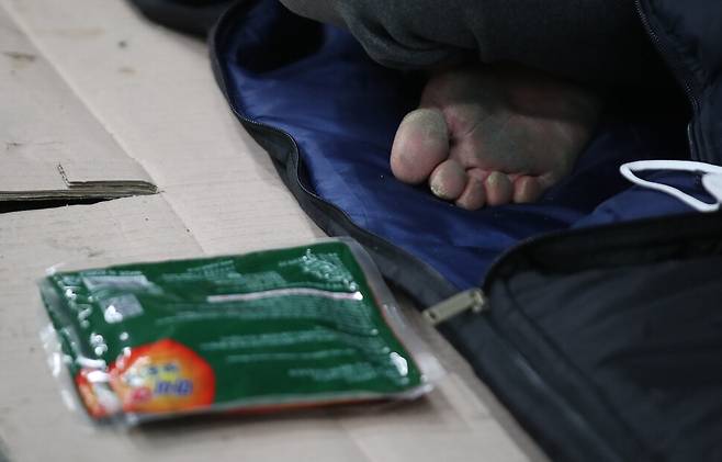 강력한 한파가 연일 계속된 10일 밤 서울역 인근 지하도에서 만난 한 노숙인이 차가운 바닥에 종이박스와 침낭을 깔고 그 위에 맨발로 앉아 있다. 그 앞에는 서울시립 다시서기종합지원센터 노숙인 아웃리치 상담원이 준 핫팩이 놓여 있다. 백소아 기자 thanks@hani.co.kr