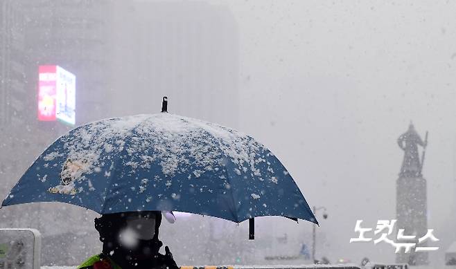 수도권을 포함한 중부지방에 낮부터 밤까지 눈이 이어질 것으로 예보된 12일 오후 서울 광화문광장에 눈이 내리고 있다. 황진환 기자