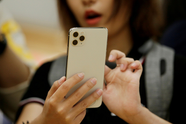 중국 베이징의 애플 매장에서 한 고객이 스마트폰을 살펴보고 있다. /로이터연합뉴스