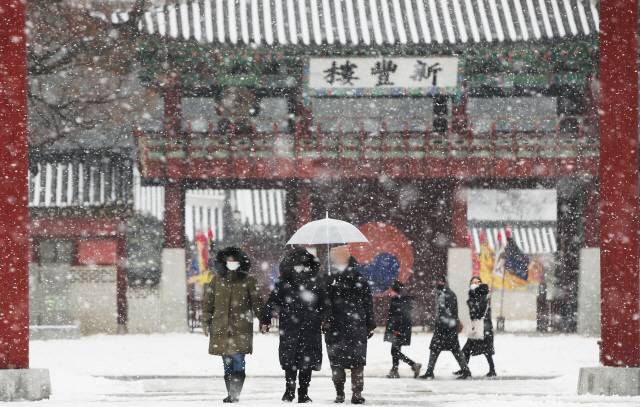 12일 오후 경기도 수원시 팔달구 화성행궁에서 시민들이 눈을 맞으며 걷고 있다./수원=연합뉴스