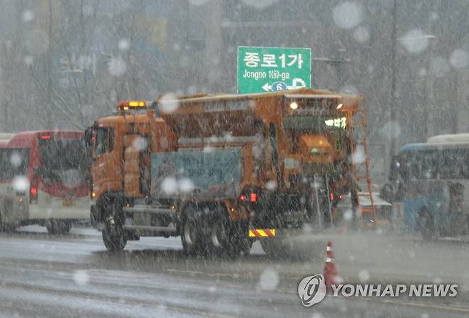 분주히 오가는 제설차량 (서울=연합뉴스) 홍해인 기자 = 서울 지역에 눈이 내린 12일 오후 서울 중구 태평로에서 제설차량이 도로에 염화칼슘을 뿌리며 이동하고 있다. 2021.1.12 hihong@yna.co.kr