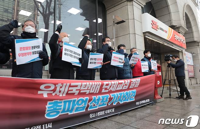 전국택배노동조합 우체국본부 관계자들이 13일 서울 종로구 광화문우체국 앞에서 열린 '우체국택배 단체교섭 결렬 총파업 선포 기자회견'에서 구호를 외치고 있다. 2021.1.13/뉴스1 © News1 이성철 기자