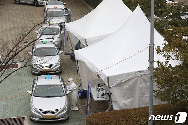 (부산=뉴스1) 여주연 기자 = 11일 오후 부산 연제구 부산아시아드주경기장 주차장에서 택시 기사들이 드라이브 스루로 신종 코로나바이러스 감염증(코로나19)검사를 받고 있다. 부산시는 오는 15일까지 지역 내 무증상 감염자 조기 발견을 위해 택시 운수종사자를 대상으로 '찾아가는 이동 선별검사소'를 운영한다. 2021.1.11/뉴스1