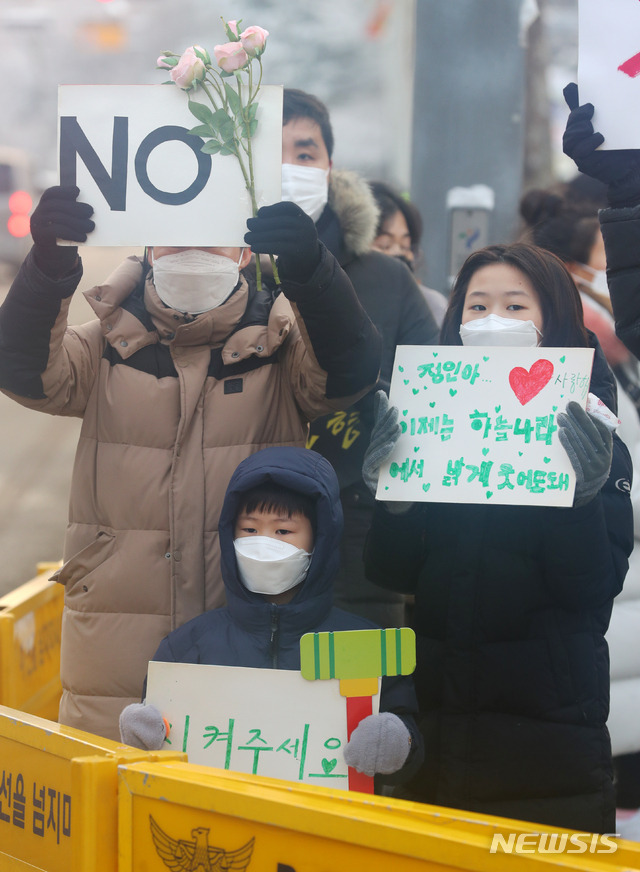 [서울=뉴시스]배훈식 기자 = 학대 받아 숨진 것으로 알려진 정인이 양부모에 대한 첫 재판이 열리는 13일 오전 서울 양천구 서울남부지방검찰청 앞에서 한 가족이 아동학대 반대 피켓 시위를 하고 있다. 2021.01.13. dahora83@newsis.com