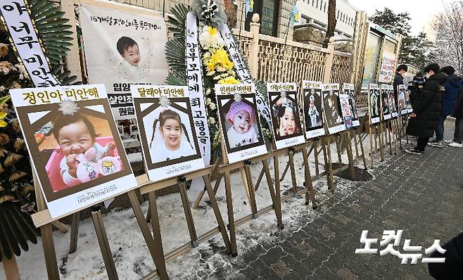 16개월 된 입양 딸 정인양을 학대해 숨지게 한 혐의를 받는 양부모에 대한 첫 공판이 열린 13일 서울 양천구 남부지방법원 앞에 학대로 숨진 아동들의 사진이 걸려 있다. 박종민 기자