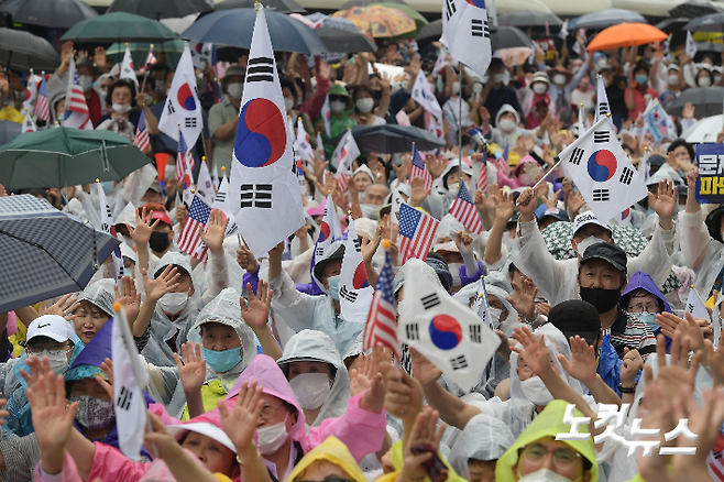 지난해 광복절 태극기 집회에서 참석자들이 태극기와 성조기를 흔들고 있다. 이한형 기자