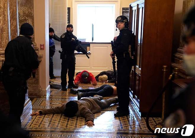 6일(현지시간) 워싱턴 의사당에 난입한 도널드 트럼프 미국 대통령 지지자들을 경찰이 체포를 하고 있다. © AFP=뉴스1 © News1 우동명 기자