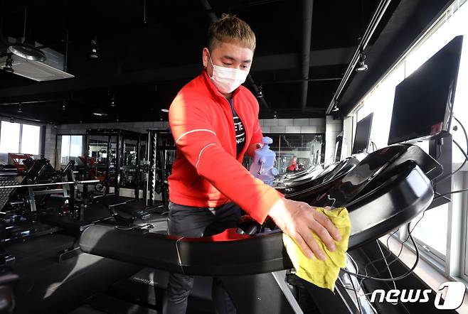 정부가 방역 조치 형평성을 고려해 거리두기 재조정을 검토하고 있는 가운데, 14일 인천시 남동구 간석동 시너지 짐 PT헬스장에서 김장환 대표가 헬스 기구 소독을 하고 있다. 2021.1.14/뉴스1 © News1 정진욱 기자