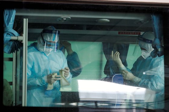 14일 우여곡절 끝에 중국에 코로나 19 기원을 조사하기 위해 입국한 세계보건기구(WHO) 직원들이 우한에 도착해 버스 안에서 방호복을 입고 대기하고 있다.[로이터=연합뉴스]