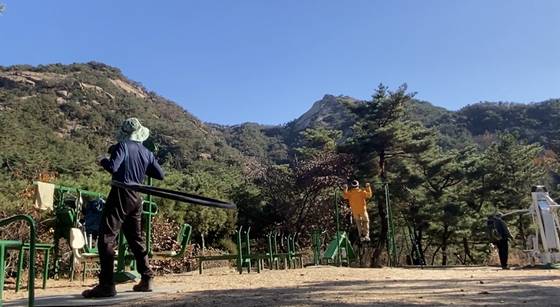 People making use of exercise equipment installed by Mount Bukhan. [KIM HONG-JOON]