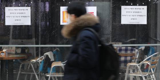 A sign announcing that the business is temporary suspended posted on an empty restaurant in downtown Seoul on Thursday. [YONHAP]
