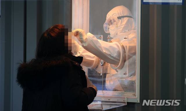 [서울=뉴시스]김선웅 기자 = 524명의 신규 코로나19 확진자가 발생한 14일 오전 서울역 광장에 설치된 중구 임시 선별검사소에서 의료진이 검체를 채취하고 있다. 2021.01.14. mangusta@newsis.com