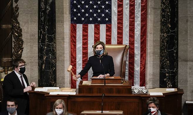 &nbsp;도널드 트럼프 미국 대통령에 대한 탄핵소추안 표결을 진행하는 낸시 펠로시 하원의장이 13일(현지시간) 하원 본회의장 내 의장석에서 의사봉을 두드리고 있다. 워싱턴=AP연합뉴스