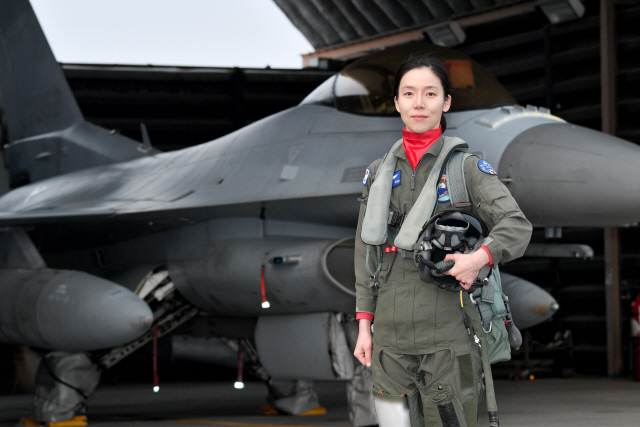 여군 최초로 ‘전술무기교관’ 자격을 획득한 공군 39정찰비행단 159전투정찰비행대대 소속 김선옥 소령(진급예정)이 자신의 주기종인 F-16 전투기 앞에서 포즈를 취하고 있다.    /사진제공=공군