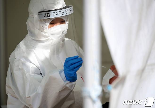 한파가 기승을 부린 6일 대구 두류공원 야구장에 마련된 임시선별진료소에서 신종 코로나바이러스 감염증(코로나19) 검사에 투입된 민간의료기관 간호사들이 추위와 싸우며 검체를 채취하고 있다. 사진은 기사와 직접적 관련 없음.  2021.1.6/뉴스1 © News1 공정식 기자