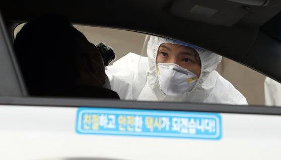 지난 11일 부산지역 택시 기사들이 연제구 아시아드주경기장 주차장에 마련된 이동 선별검사소에서 드라이브스루 방식으로 코로나19 진단검사를 받고 있다. 송봉근 기자