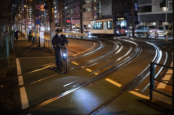14일 저녁 경찰이 긴급사태 발령으로 인적이 드문 도쿄 시내를 자전거로 순찰하고 있다. [AP=연합뉴스]