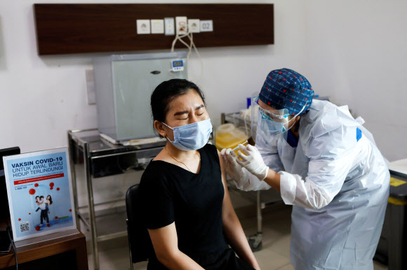 인도네시아 자카르타의 한 병원에서 14일 한 젊은 여성이 코로나19 백신을 맞고 있다.자카르타 로이터 연합뉴스