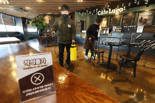 매장 이용 허가를 하루 앞둔 17일 오후 대구 달서구 이월드 내 카페에서 직원들이 방역작업과 더불어 치웠던 의자를 테이블마다 다시 놓고 있다. (사진=연합뉴스)