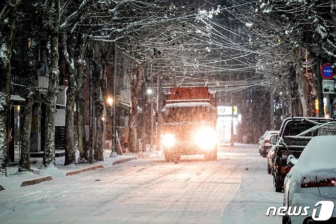6일 오후 곳곳에 한파와 대설 특보가 발효된 가운데 서울 마포구 홍대입구역 인근에 눈이 쌓이고 있다. 제설차량이 이면도로 눈을 치우며 염화칼슘을 뿌리고 있다. 2020.1.6/뉴스1 © News1 황덕현 기자