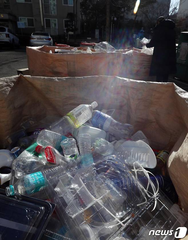 (남양주=뉴스1) 김명섭 기자 = 25일 경기도 남양주시 한 아파트단지 분리수거장에서 투명색 페트병과 유색 플라스틱 재활용품들이 섞여서 배출되고 있다. 이날 부터 300가구 이상 또는 엘리베이터가 설치됐거나 공동난방을 하는 150~299가구 규모 단지는 ‘투명 페트(PET)병 별도 분리 배출제’가 의무화된다. 2020.12.25/뉴스1