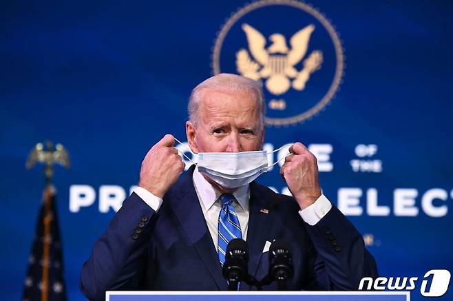 조 바이든 미국 대통령 당선인이 14일(현지시간) 델라웨어주 윌밍턴에 있는 퀸 시어터에서 1조9000억달러(약 2082조원) 규모의 코로나19 경기 부양책을 발표하기 전에 마스크를 벗고 있다. © AFP=뉴스1 © News1 우동명 기자
