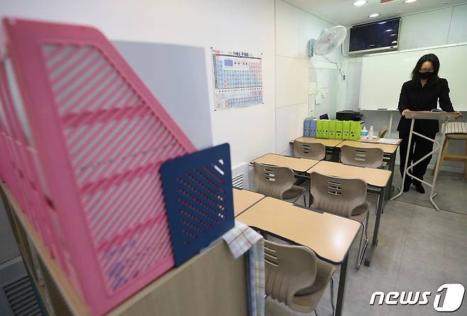 17일 오후 서울 서초구의 한 학원에서 한 선생님이 수업준비를 하고 있다. 중앙재난안전대책본부(중대본)는 신종 코로나바이러스 감염증(코로나19) 확산 방지를 위해 17일까지 적용될 예정이던 수도권 거리두기 2.5단계, 비수도권 2단계 조처를 31일까지 2주간 연장한면서 18일부터 수도권 학원·교습소에는 Δ8㎡당 1명으로 인원제한 또는 좌석 두 칸 띄우기 Δ시설 내 최소 1m 이상 거리두기 Δ음식섭취 금지 Δ오후 9시 이후 운영중단 등 수칙을 준수하면서 인원제한 없이 대면수업을 할 수 있게 했다. 2021.1.17/뉴스1 © News1 임세영 기자