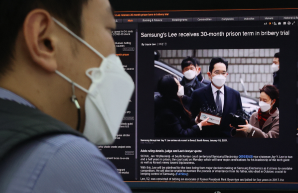 18일 오후 서울 중구 을지로 하나은행 본점 딜링룸에서 한 직원이 컴퓨터 모니터에 이재용 삼성전자 부회장의 법정구속 관련 뉴스를 띄워놓고 있다. /연합뉴스