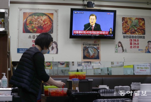 경험해보지 못한 기자회견
18일 오전 서울 종로구의 한 식당에서 직원이 영업 준비를 하며 문재인 대통령의 신년 기자회견을 청취하고 있다. 송은석기자 silverstone@donga.com