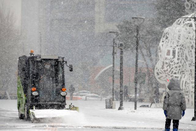 서울과 수도권 일부 지역에 대설주의보가 발효된 지난 12일 서울 송파구 롯데월드타워 인근에서 제설작업이 진행되고 있다. 기상청이 이날 수도권에 1~3cm의 눈을 예보한 것과 달리 서울에는 5cm의 눈이 내려 퇴근길 곳곳에서 교통체증으로 시민들이 큰 불편을 겪었다. 뉴스1