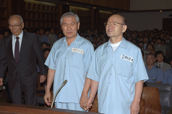 In this file photo, former Presidents Chun Doo Hwan, left, and Roh Tae-woo, stood in the courtroom in 1996 for their treason trial. [YONHAP]
